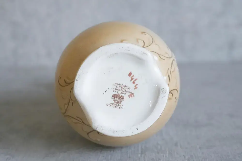 イギリスのCrown Devon(クラウンデボン)のロマンティックなペンダント模様が描かれたアンティークフラワーベース
イギリスのCrown Devon(クラウンデボン)は、1878年に創業された陶磁器ブランドです。イギリスの陶磁器生産地、ストーク・オン・トレントで操業していたことで有名です。
底面にあるバックスタンプには下記の通り記されています。
「CROWN DEVON S.F&co STOKE ON TRENT ENGLAND PENDANT」5